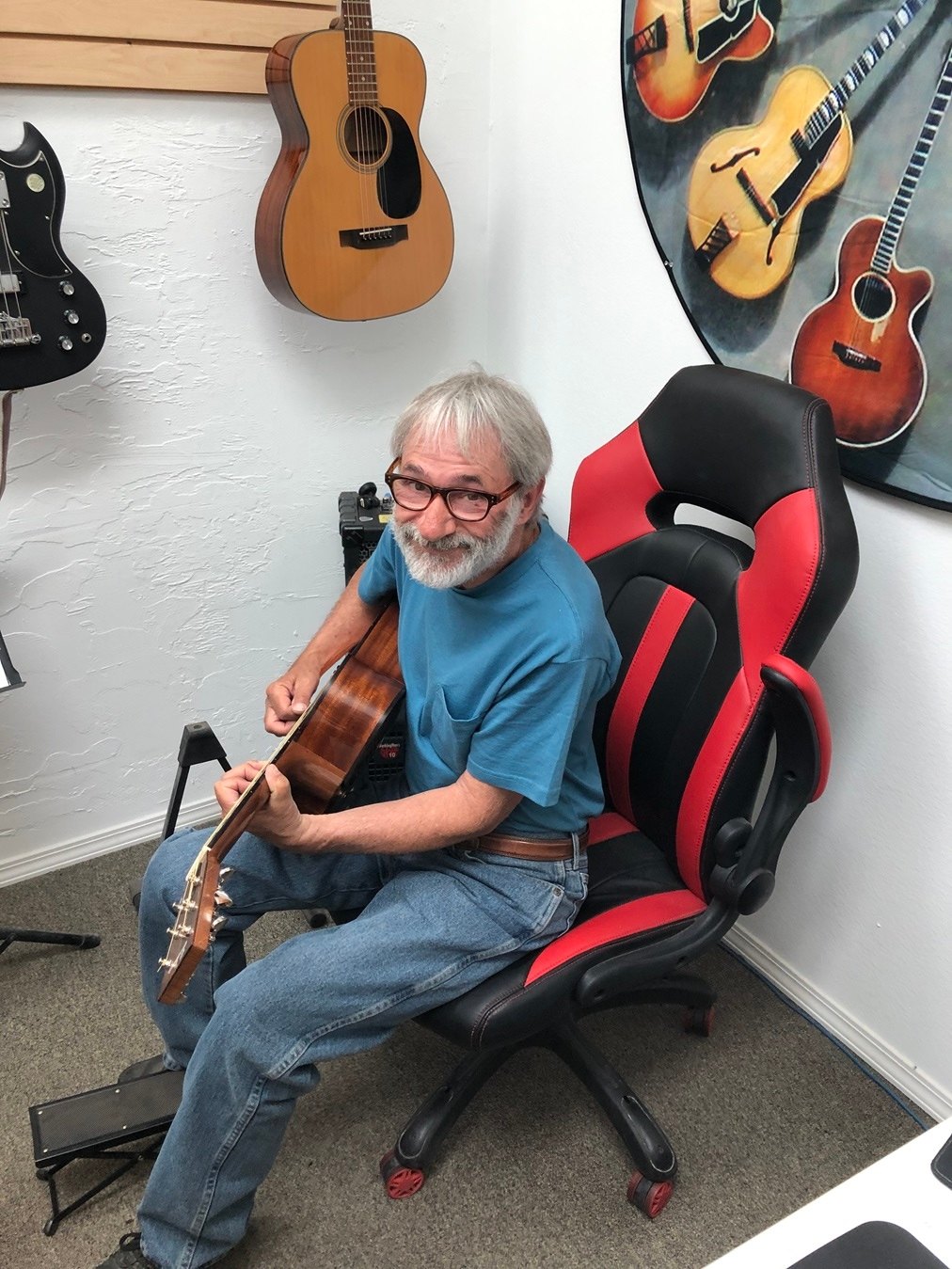 Dave Stinski sitting with a guitar in one of the lesson rooms at The Guitar Shop