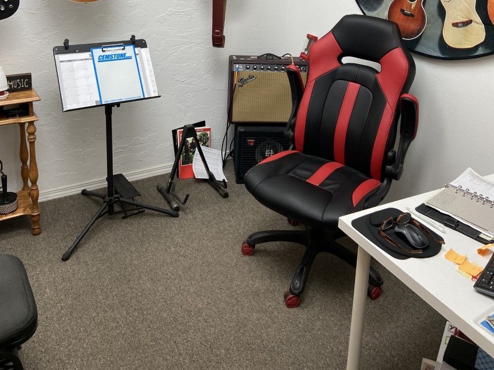 Lesson room with a Gibson acoustic and a Les Paul on the wall rack