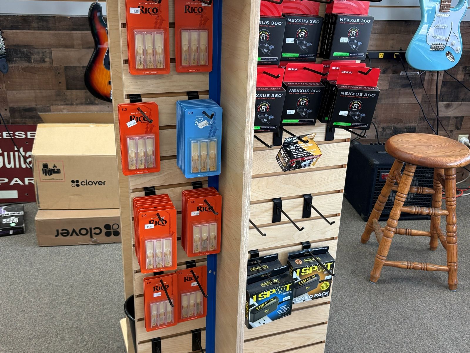 A spinner rack of reeds and small accessories in front of the bass wall