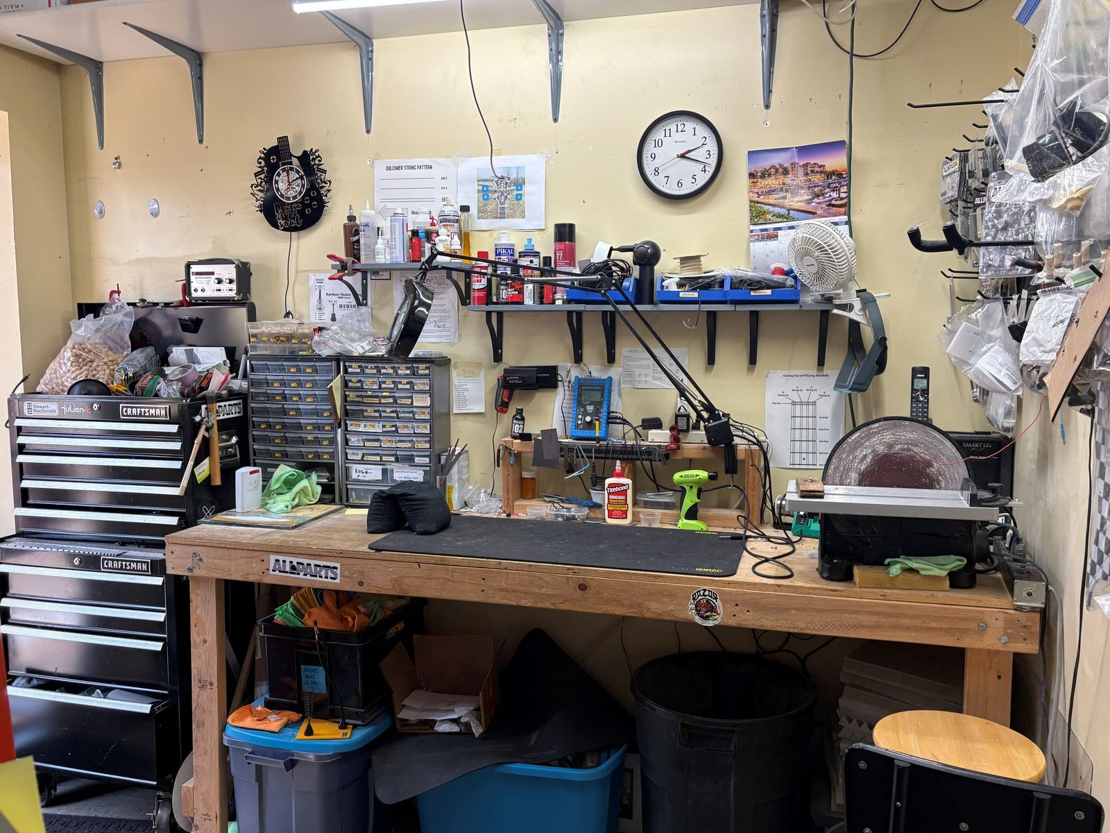 The full repair room: bench, tool chest, parts drawers and the magnifier lamp